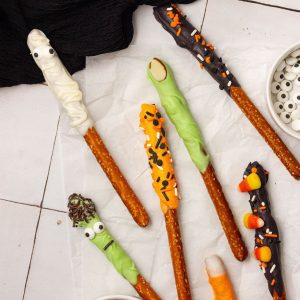 halloween pretzel rods decorated with colored chocolate and sprinkles