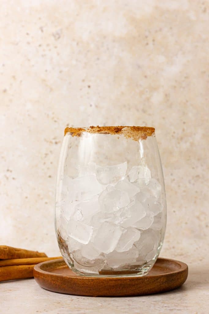 glass filled with ice on wood coaster