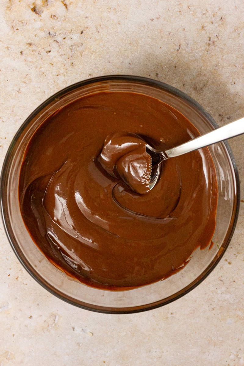 melted chocolate with a spoon in glass bowl