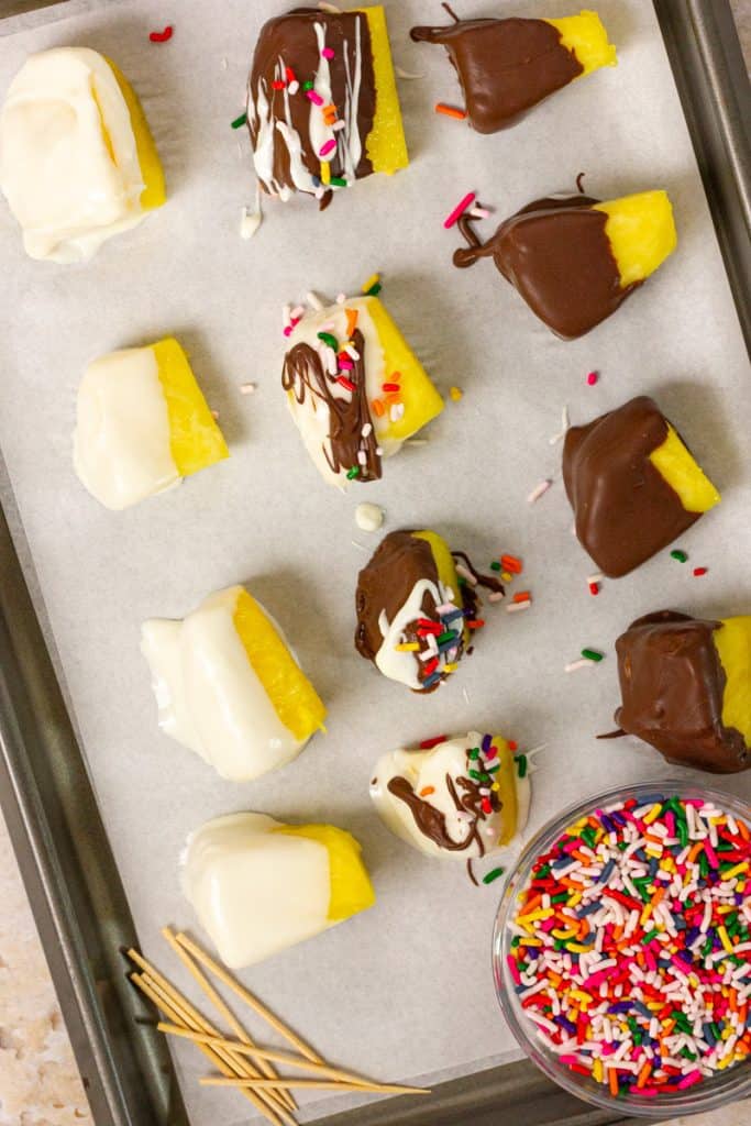 chocolate covered pineapple on baking sheet with parchment paper