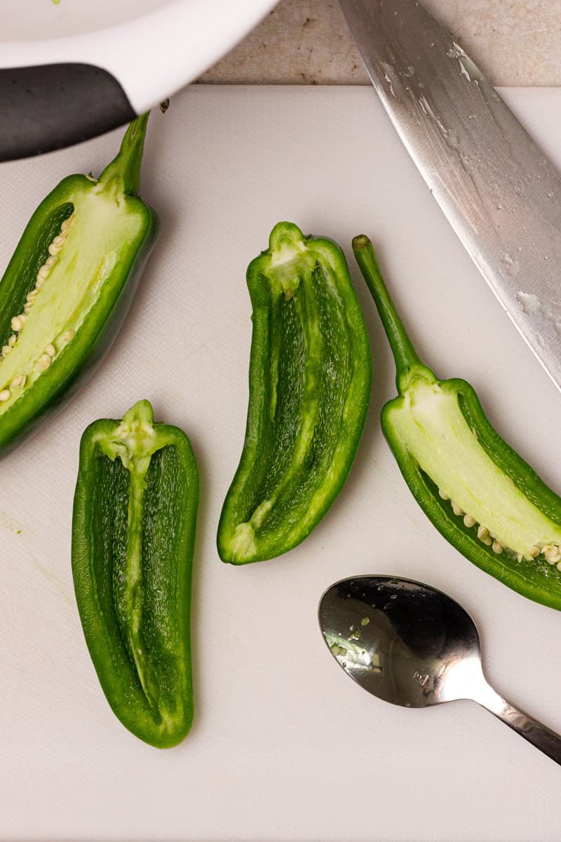 scooping out seeds and membrane from jalapeno peppers