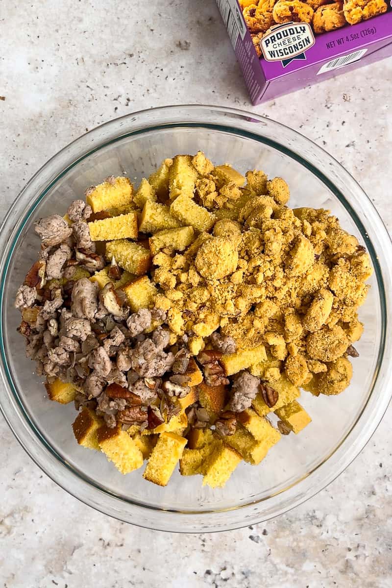 Crushed crackers, cornbread, and ground turkey combined in a clear glass bowl.