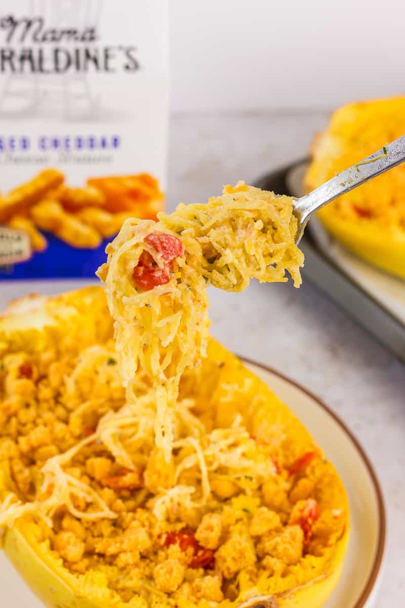 Forkful of cheesy spaghetti squash topped with crunchy cheddar crumbs, showcasing the final dish.
