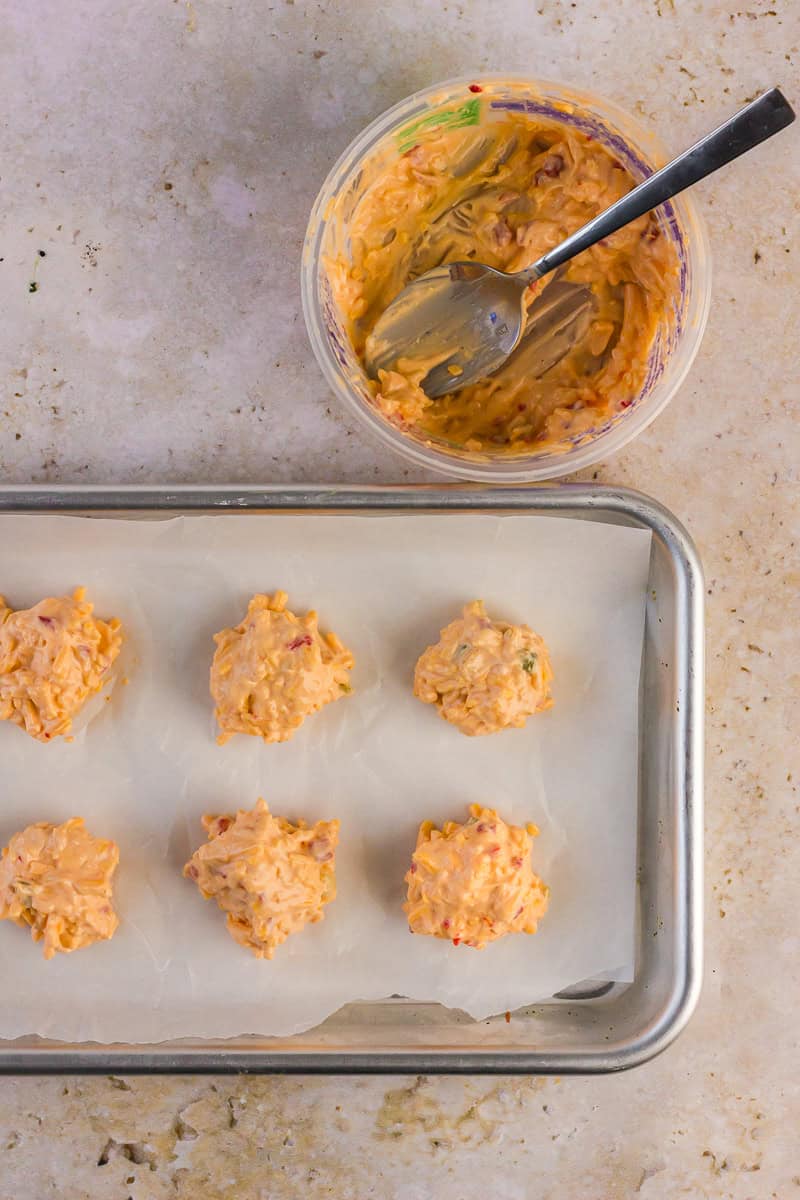 Scooped pimento cheese ready to freeze on a parchment-lined tray.