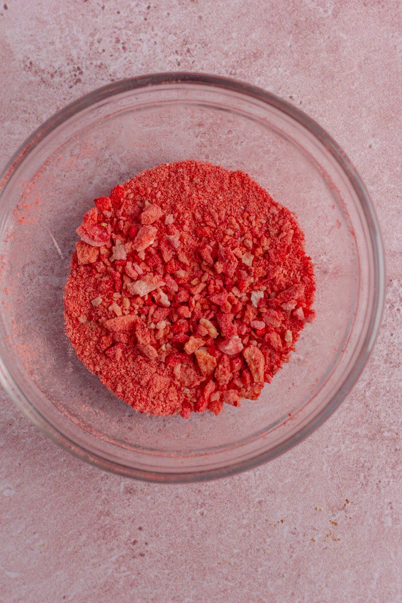 A glass bowl containing crushed freeze-dried strawberries for a crunchy topping.