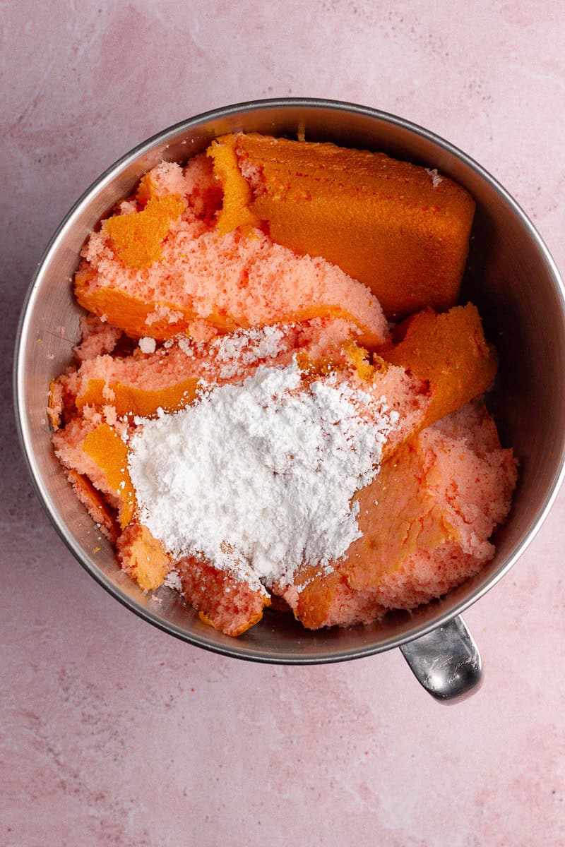 A mixing bowl with crumbled strawberry cake and powdered sugar, ready to be combined.