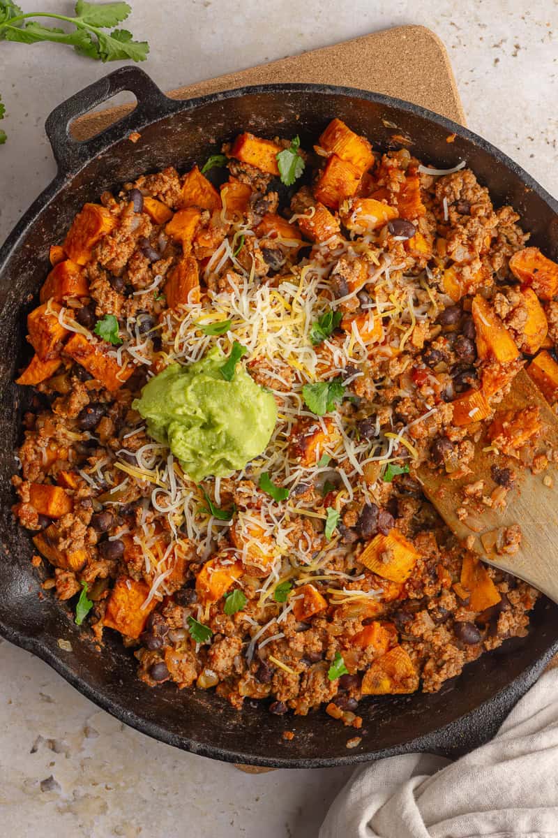 Overhead shot of sweet potato taco skillet with a wooden spoon.