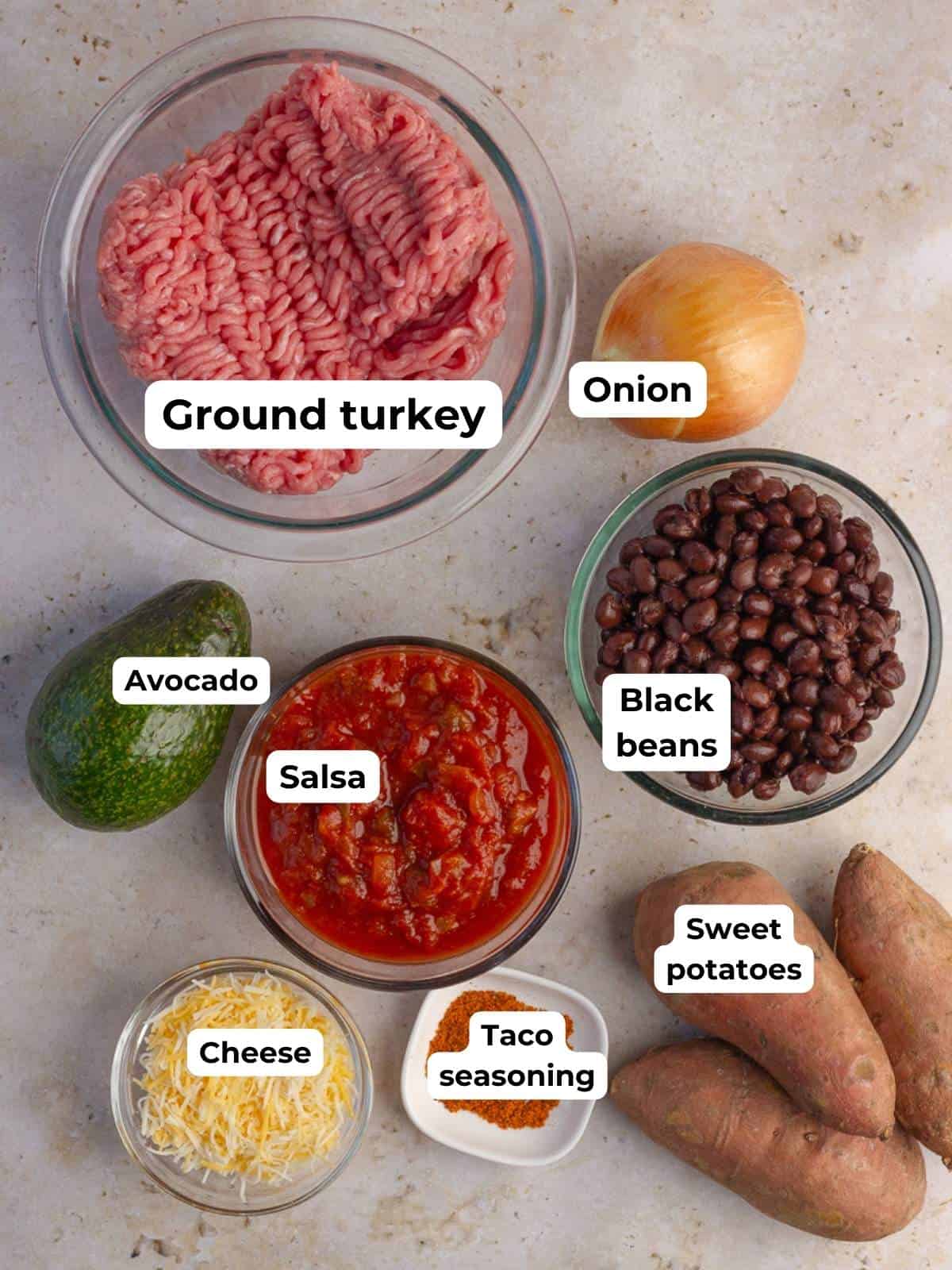 Ingredients for sweet potato taco skillet, including ground turkey, sweet potatoes, salsa, black beans, cheese, and taco seasoning.