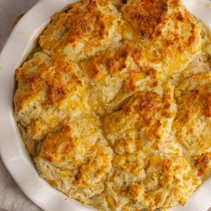 Close-up of the golden, cheesy biscuit topping on the chicken pot pie.