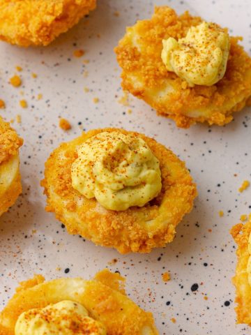 Finished crispy air fryer deviled eggs served on a plate, ready to eat.