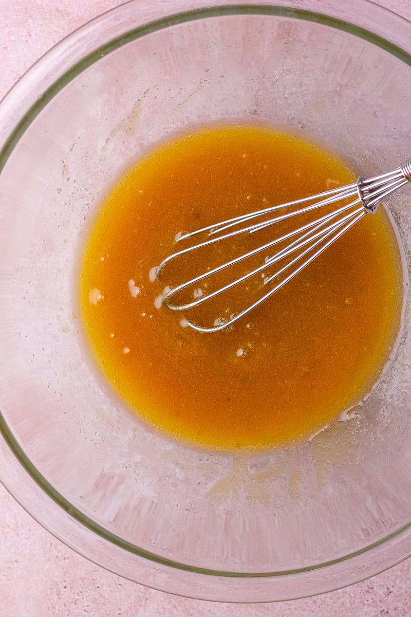 Whisked butter and brown sugar mixture in a glass bowl.