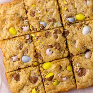 A top-down view of sliced Cadbury egg cookie bars on parchment paper.