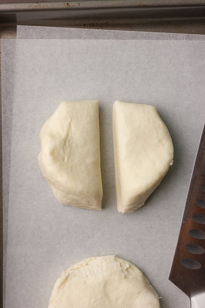 One biscuit cut in half to create bunny ears on parchment paper.