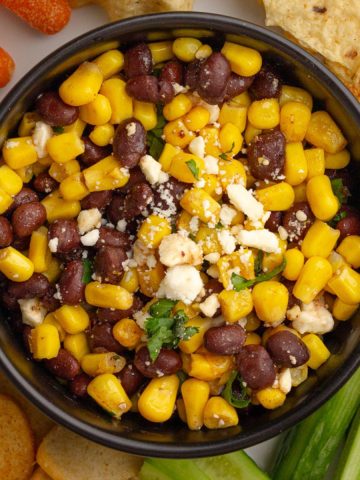 Overhead view of the finished black bean corn feta dip garnished with feta and cilantro.
