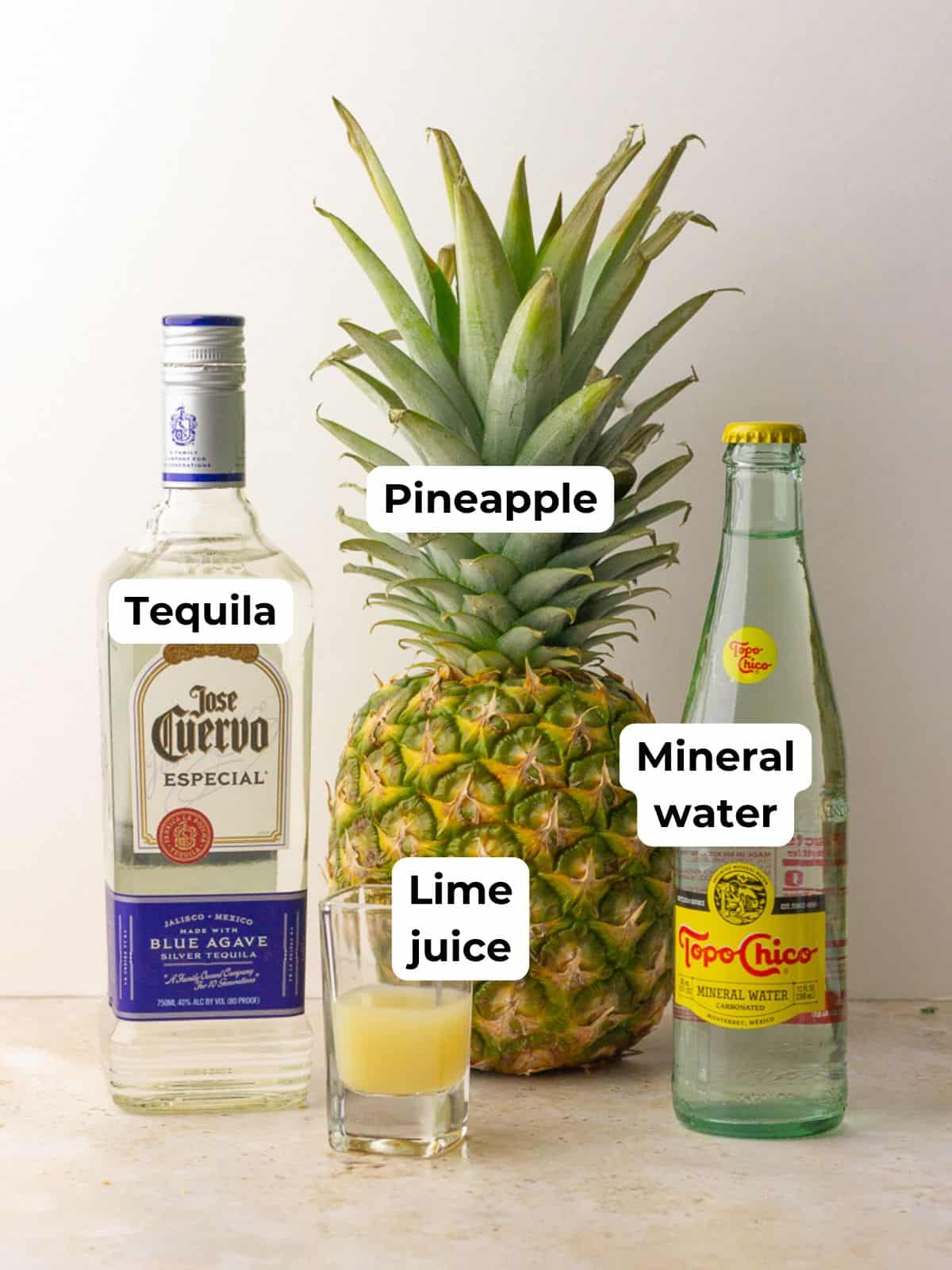 Ingredients for pineapple ranch water displayed together: tequila, pineapple, lime juice, and a bottle of Topo Chico.