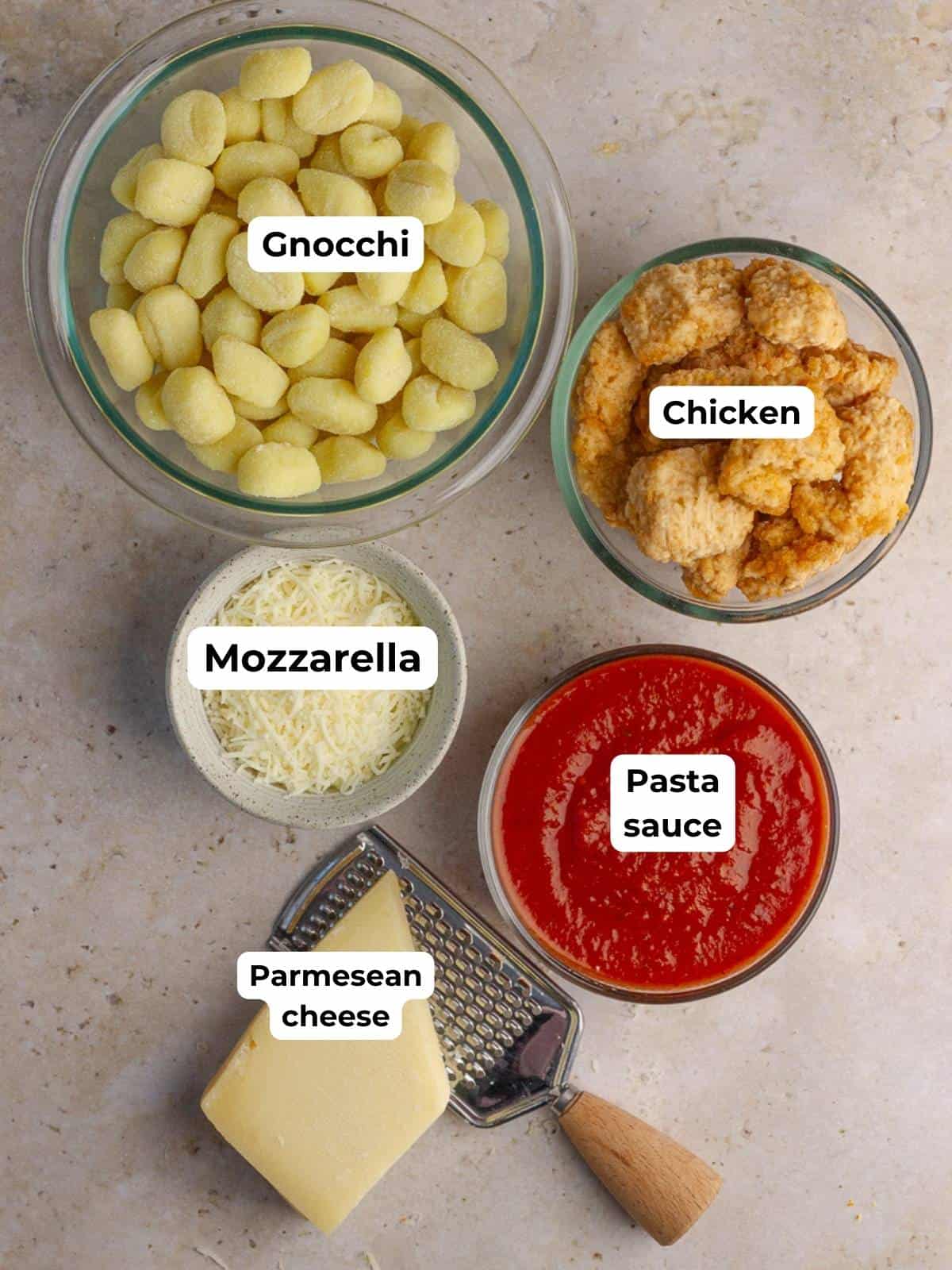 Overhead view of labeled ingredients including gnocchi, chicken, mozzarella, marinara, and parmesan.