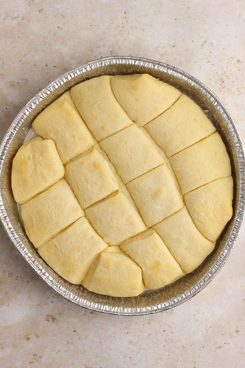 Sister Schubert rolls ready to be baked on a tan counter.