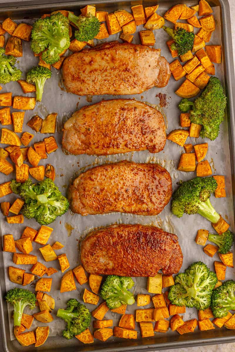 Golden-brown pork chops finished in the oven with roasted sweet potatoes and broccoli.
