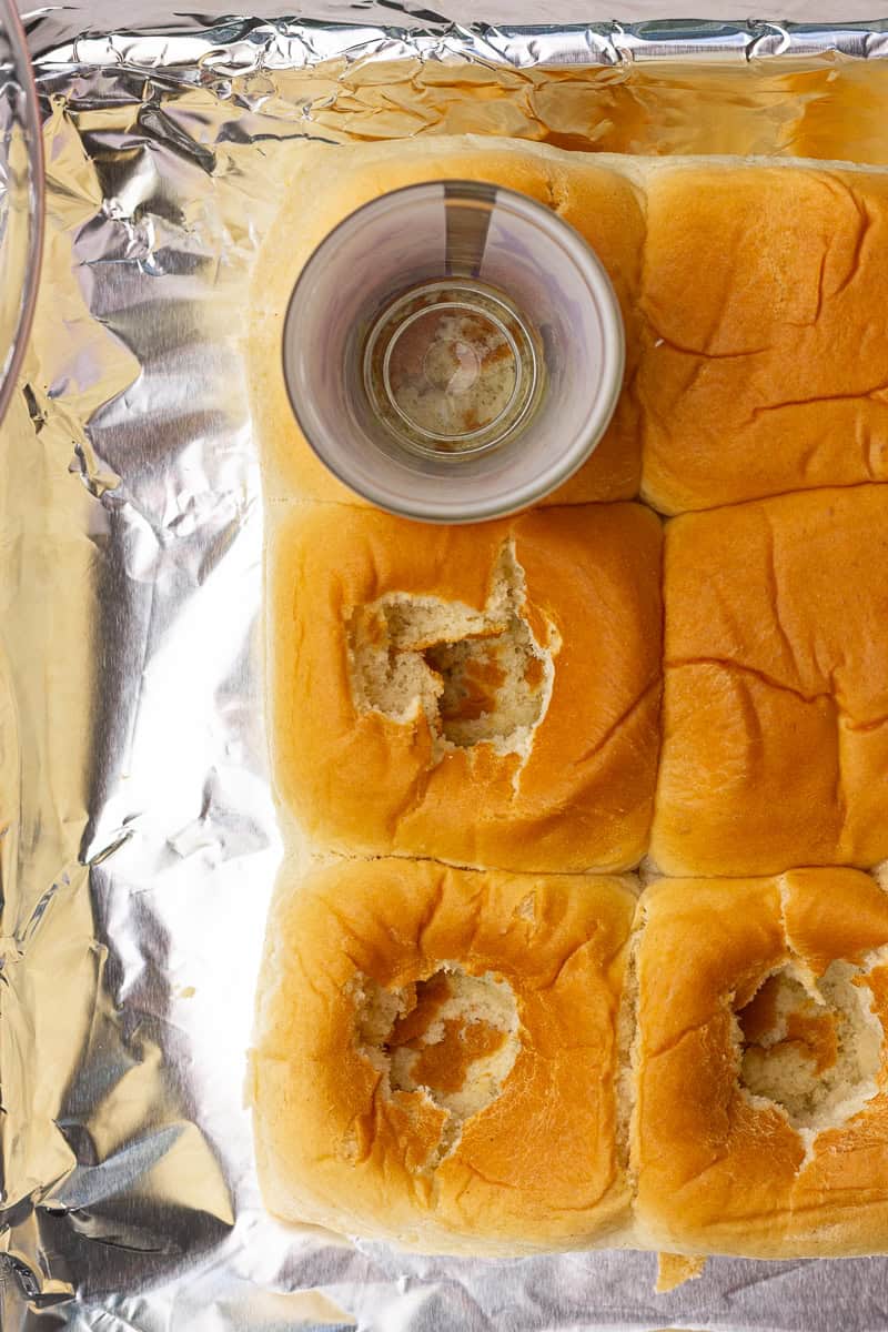 A shot glass presses into soft Hawaiian rolls to create pockets for stuffing.