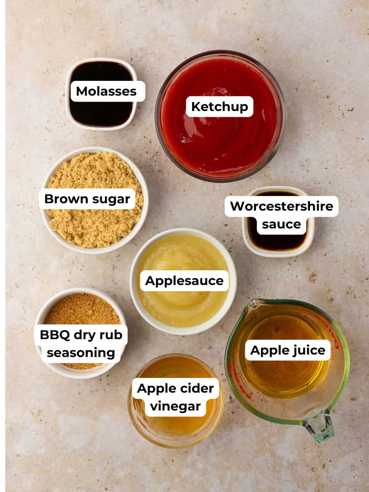 Labeled ingredients for apple BBQ sauce including ketchup, applesauce, brown sugar, vinegar, and spices.
