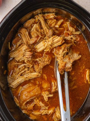 Image showing tender apple pulled pork in a black crockpot.