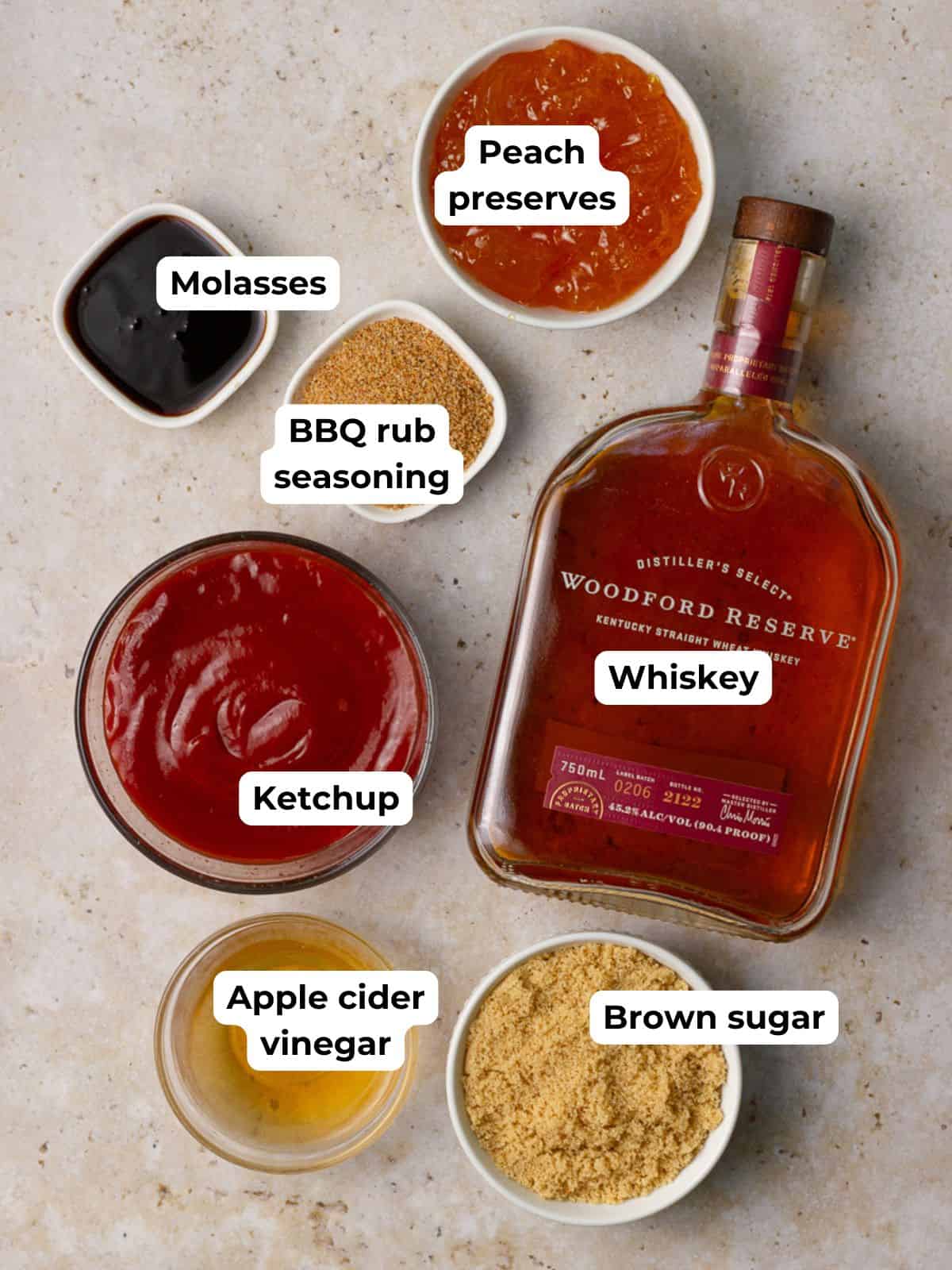 A flat lay of labeled ingredients including ketchup, peach preserves, whiskey, and spices for BBQ sauce.