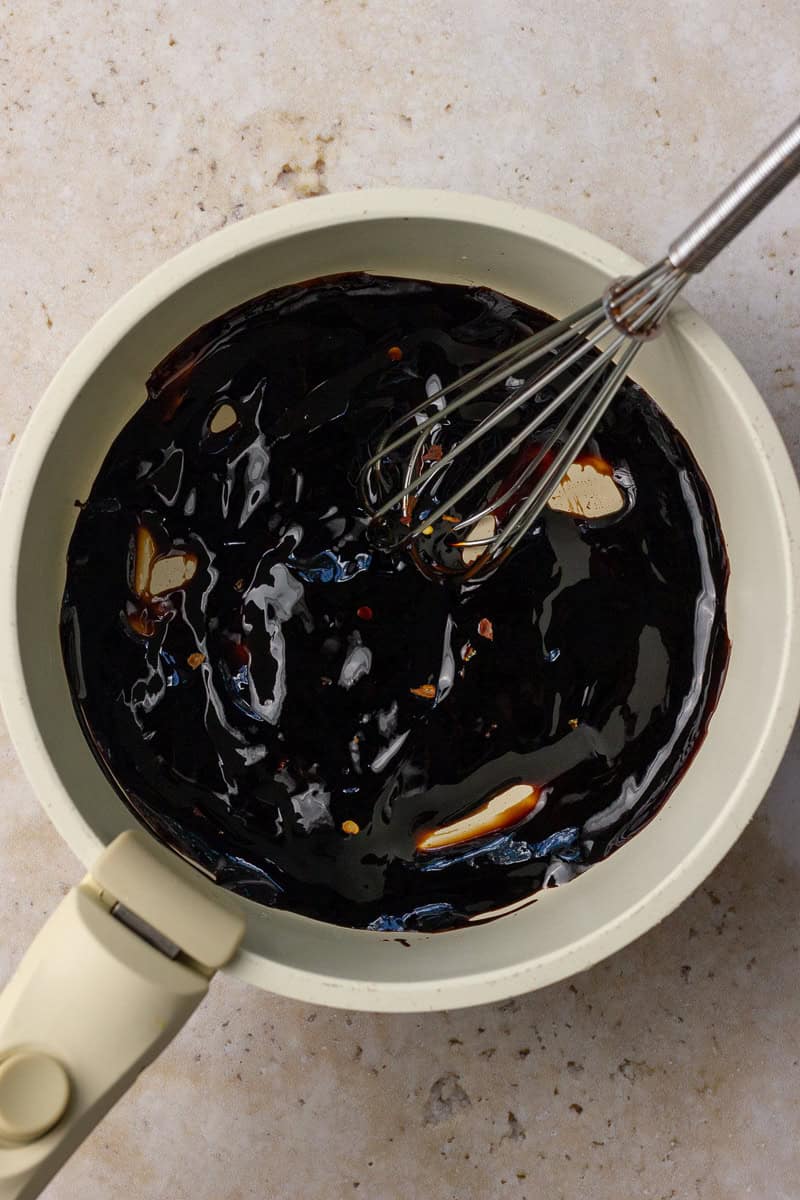The glaze thickens in the saucepan as it's whisked into a glossy, syrupy consistency.
