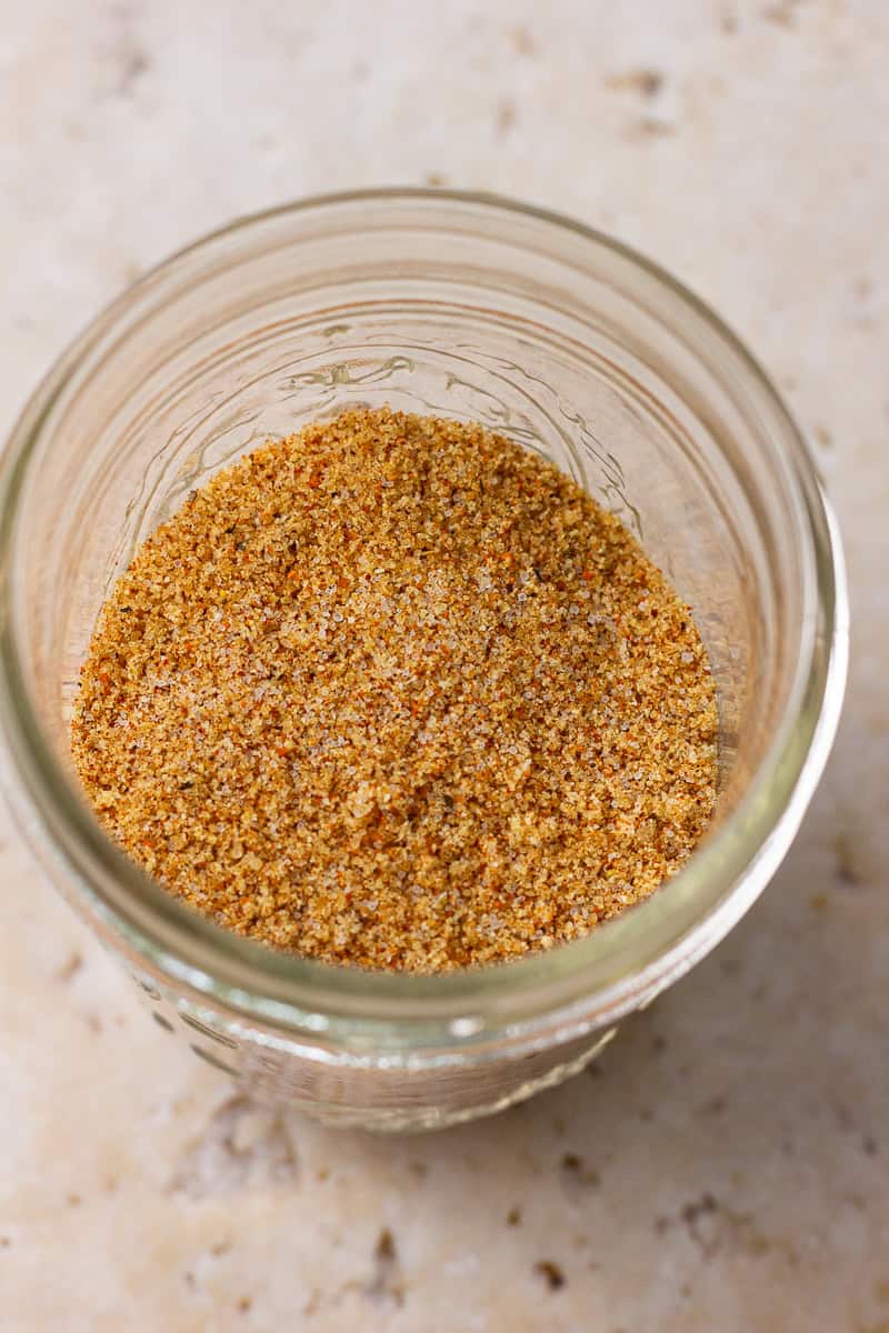 A jar filled with sweet and smoky rub viewed from above on a neutral background.