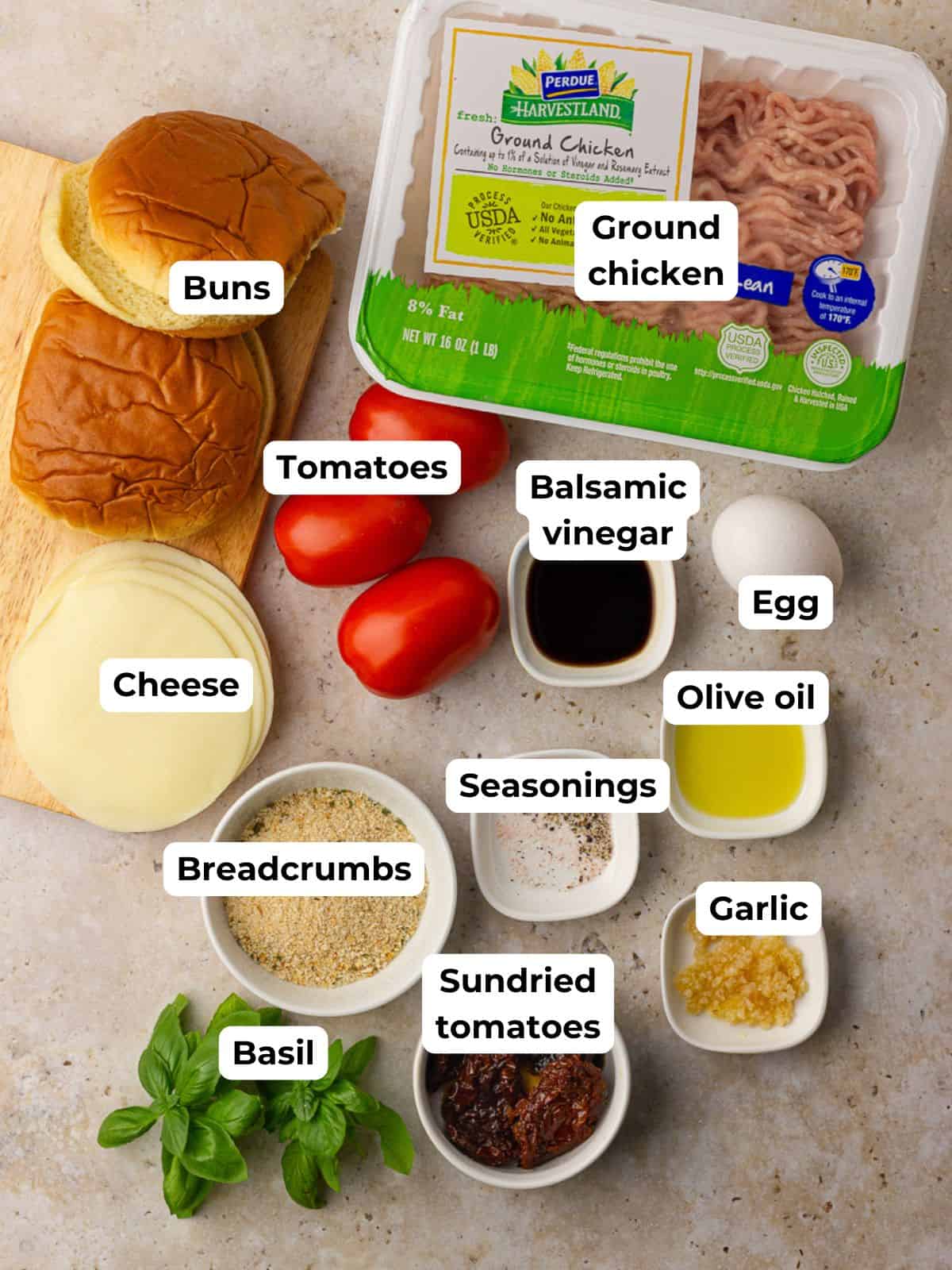 Overhead view of all ingredients for bruschetta chicken burgers laid out on a kitchen counter.