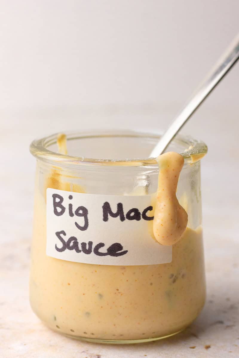 A small glass jar labeled “Big Mac Sauce” filled with homemade healthy Big Mac sauce and a spoon resting inside.