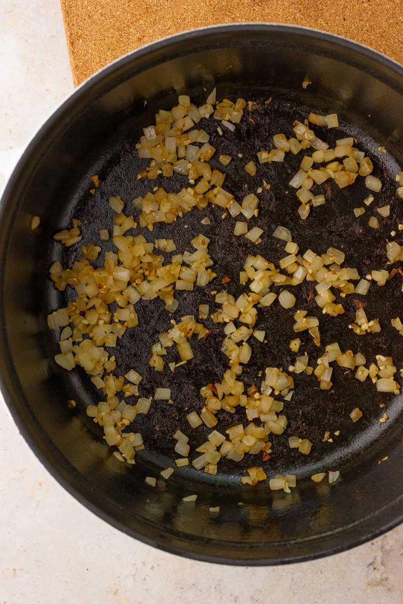 Diced onion and garlic sauté in the dutch oven pot.