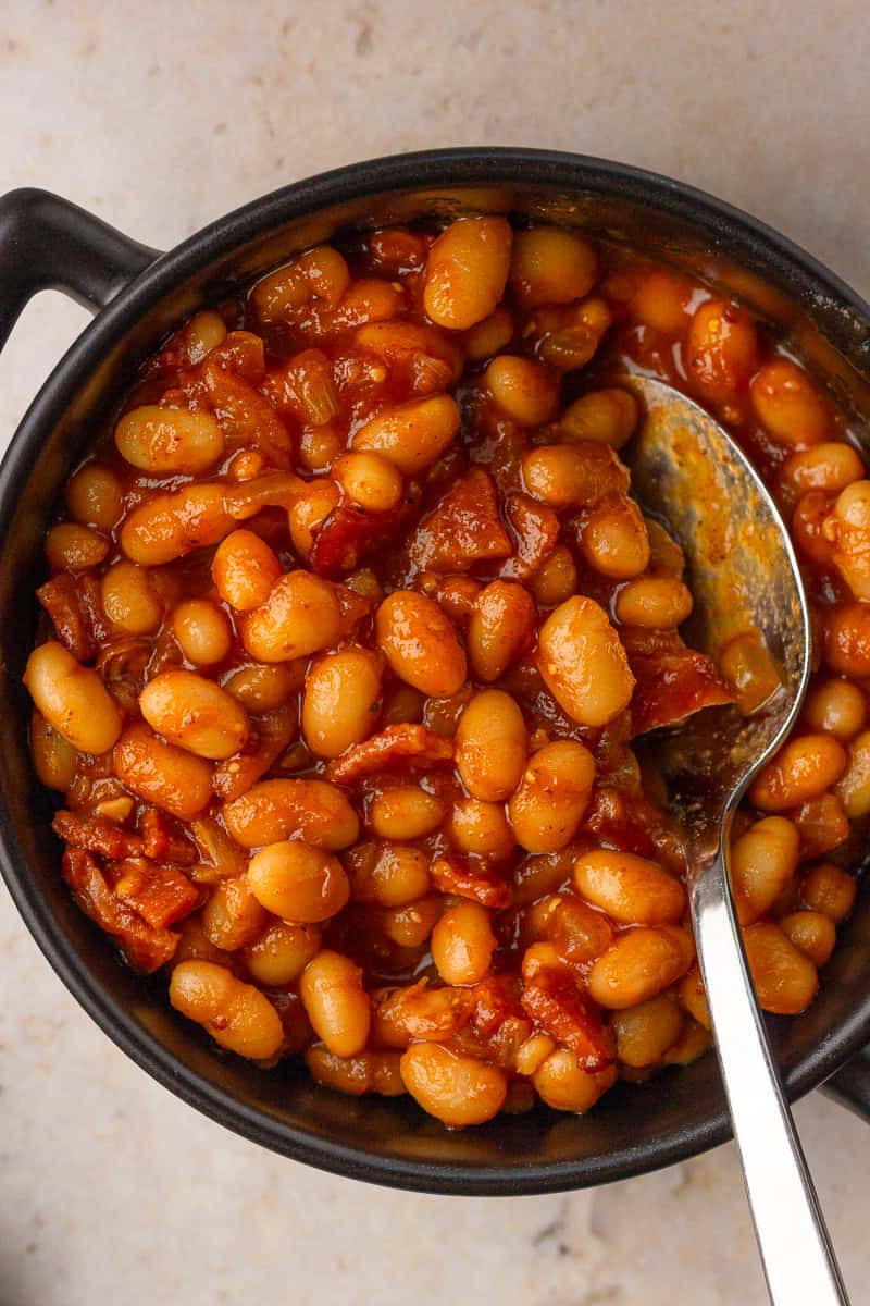 Close-up bowl of low sodium baked beans with turkey bacon showing a jammy sauce and tender navy beans.