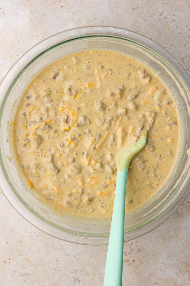 Batter mixed with turkey sausage and cheddar in a glass bowl for protein McGriddle bites.