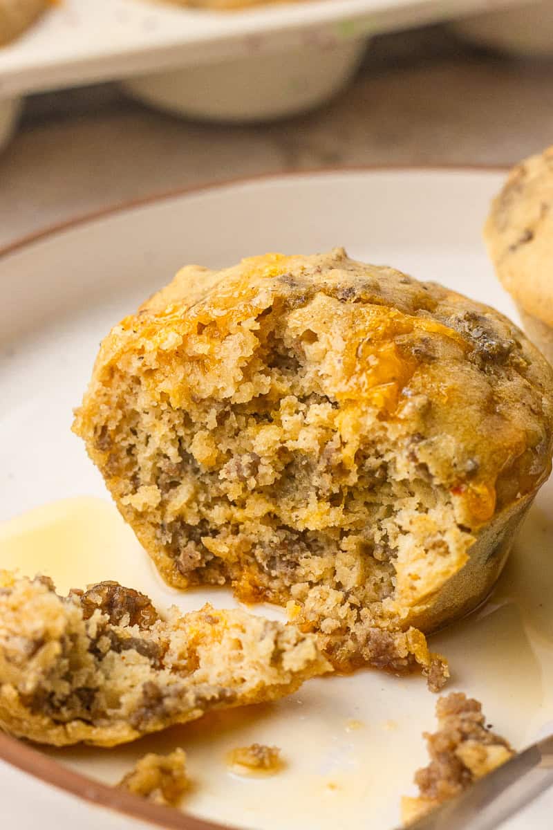 Pancake sausage muffin on a plate with maple syrup for dipping.