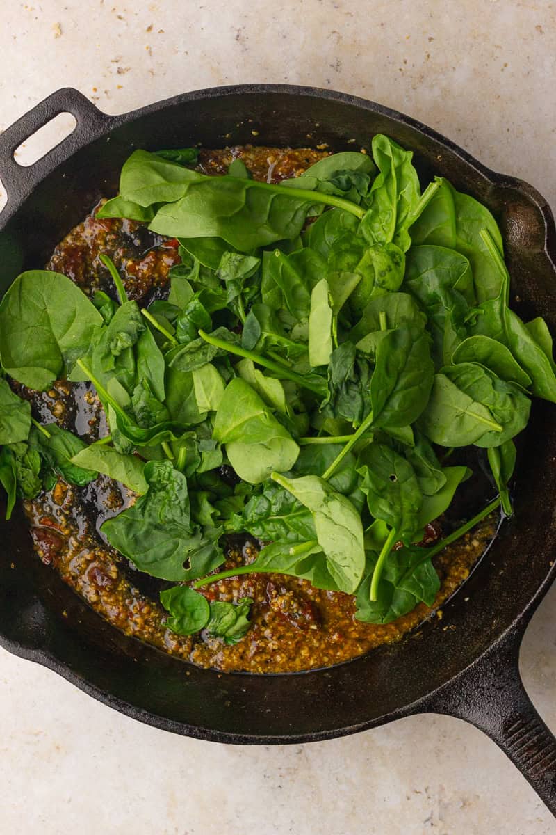 Fresh baby spinach piled into the skillet before wilting into the sauce.