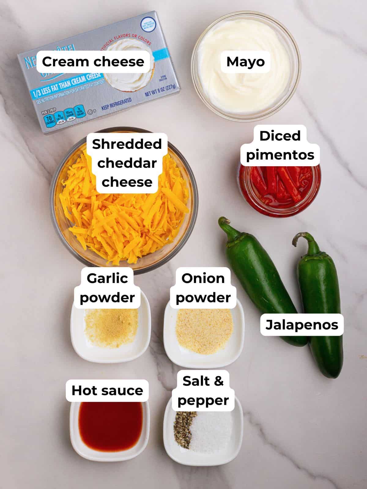 Overhead shot of labeled ingredients for baked pimento cheese dip on a marble surface.