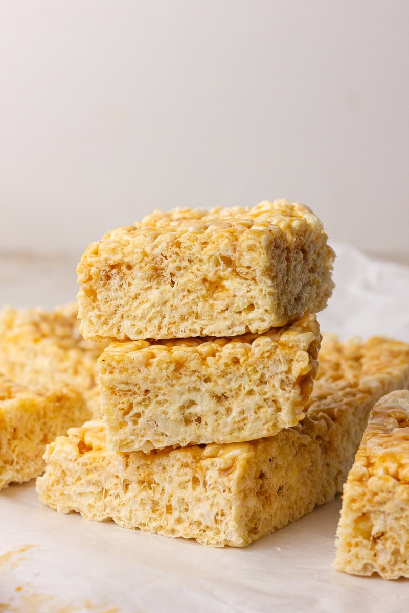 A stack of thick caramel apple Rice Krispie treats on parchment.