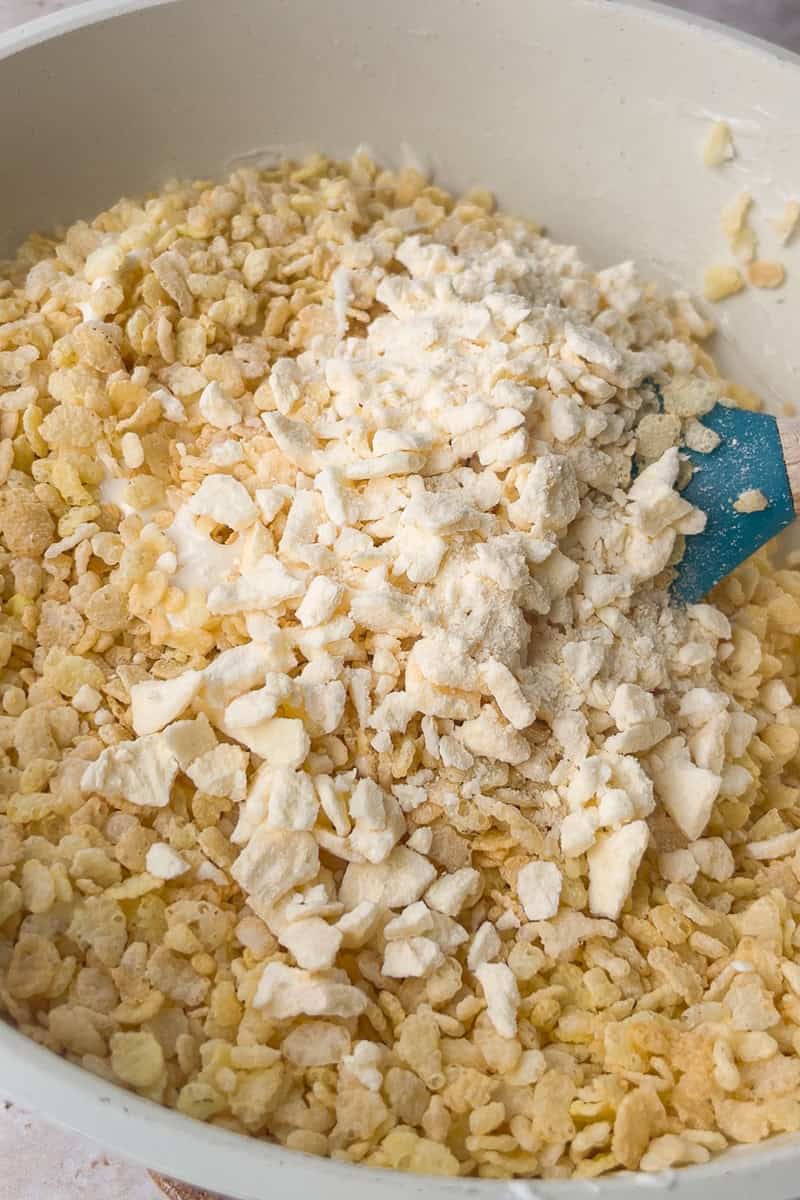 Rice cereal and crushed freeze-dried apples are added to the melted marshmallow mixture.
