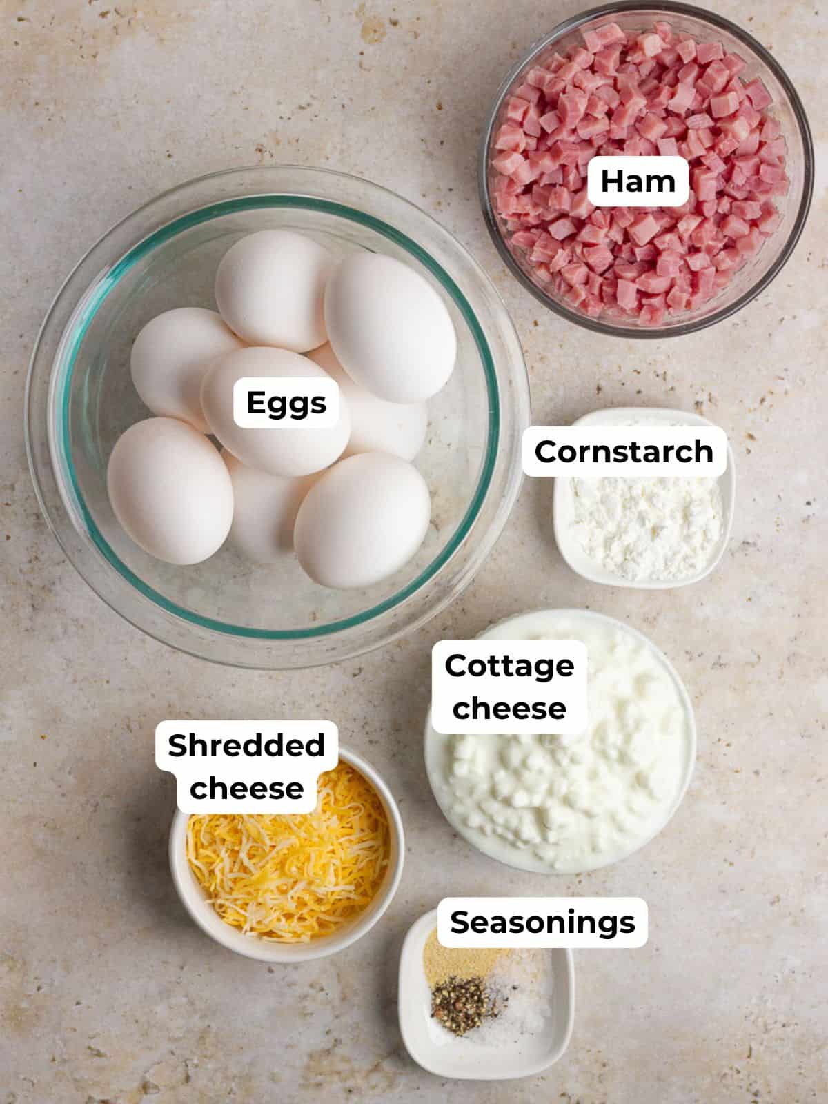 Labeled ingredients for ham and cheese egg bites including eggs, ham, cottage cheese, cornstarch, shredded cheese, and seasonings.