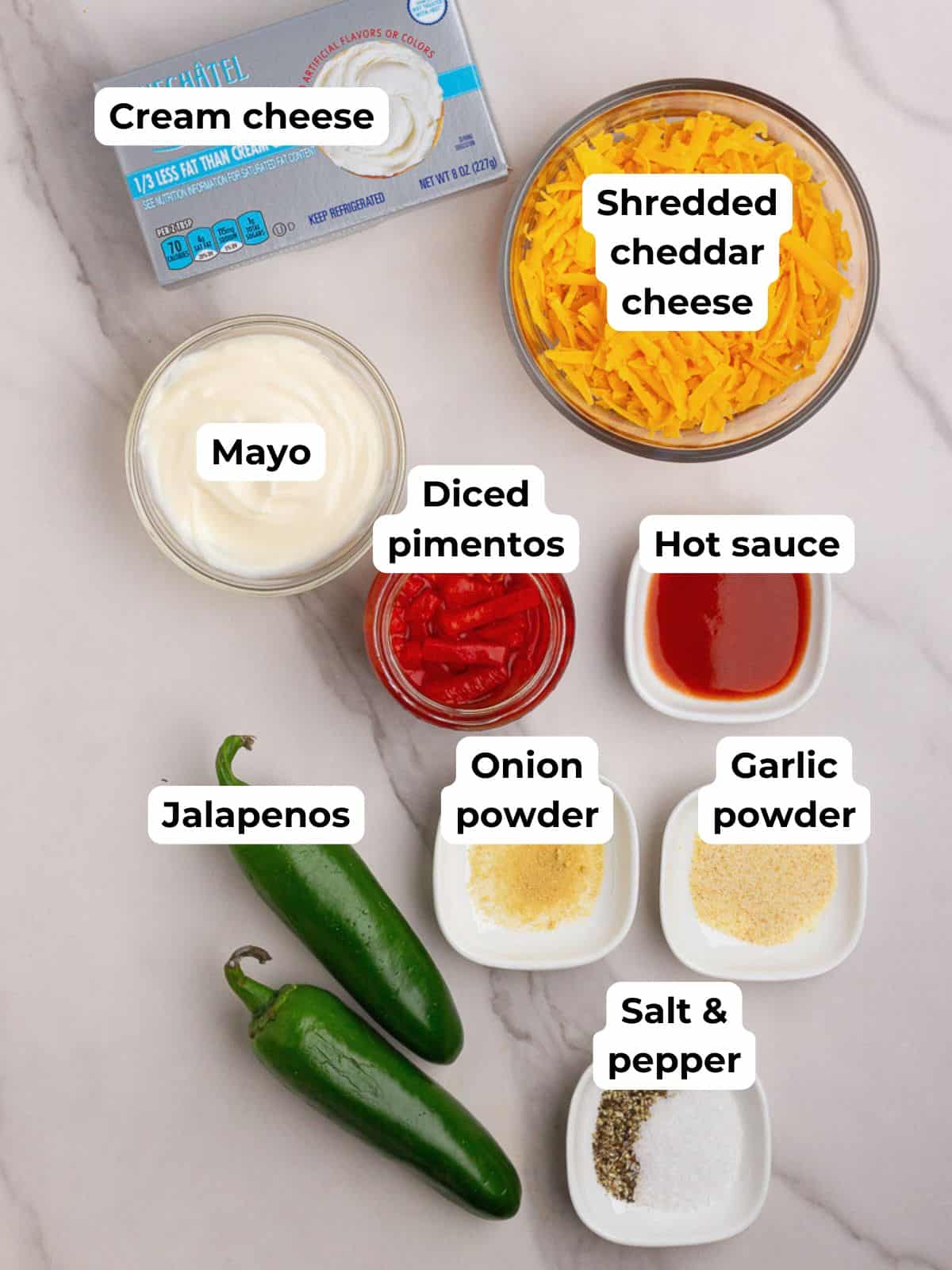 Overhead shot of labeled ingredients for jalapeño pimento cheese on a marble surface.