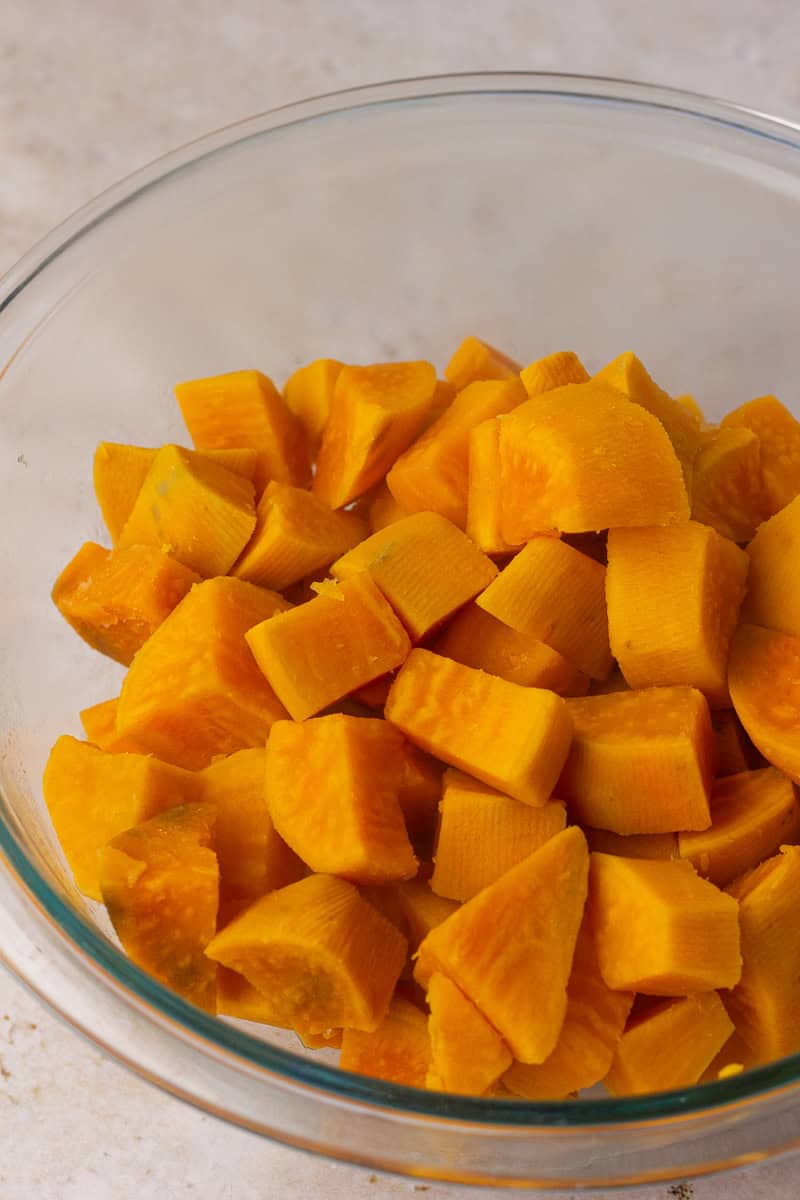 Boiled chunks of sweet potatoes in a glass bowl after cooking.