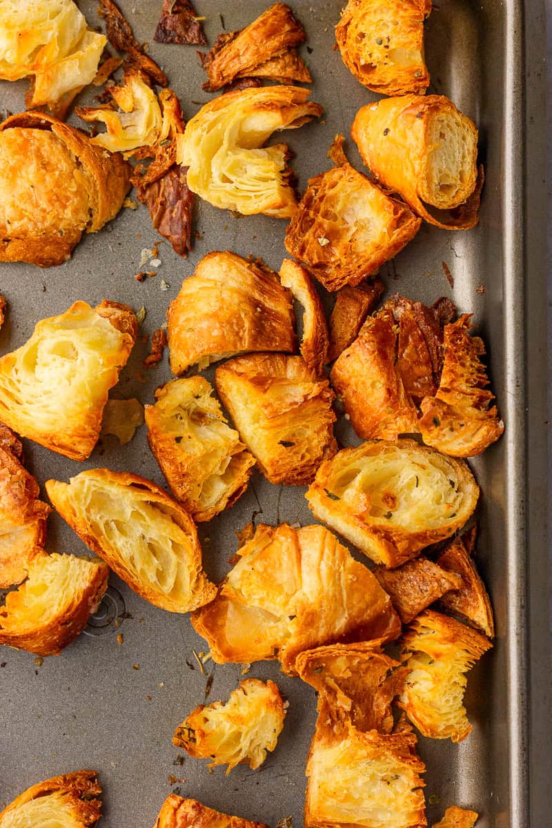 A close-up view of crispy croissant croutons highlights the toasted edges and airy centers.