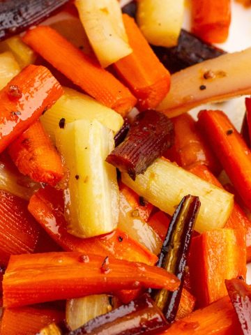 Close-up of roasted rainbow carrots showing caramelized edges and glossy glaze.
