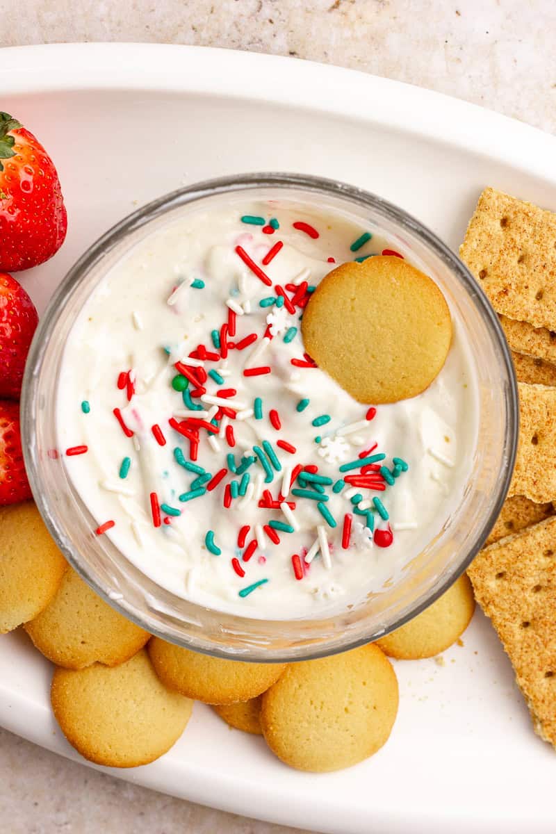 Sugar cookie dip served on a white platter with vanilla wafers, graham crackers, and fresh strawberries for dipping.