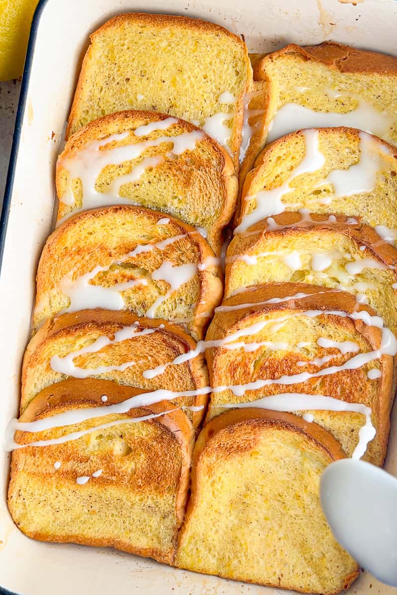 Freshly baked lemon french toast with a light lemon glaze drizzled over the top.