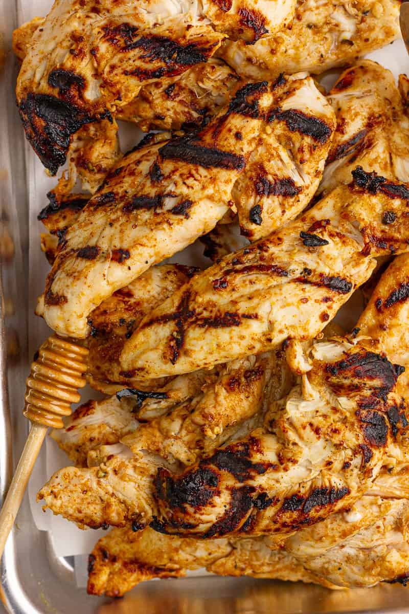 A close-up shows grilled honey mustard chicken tenders with charred grill marks.