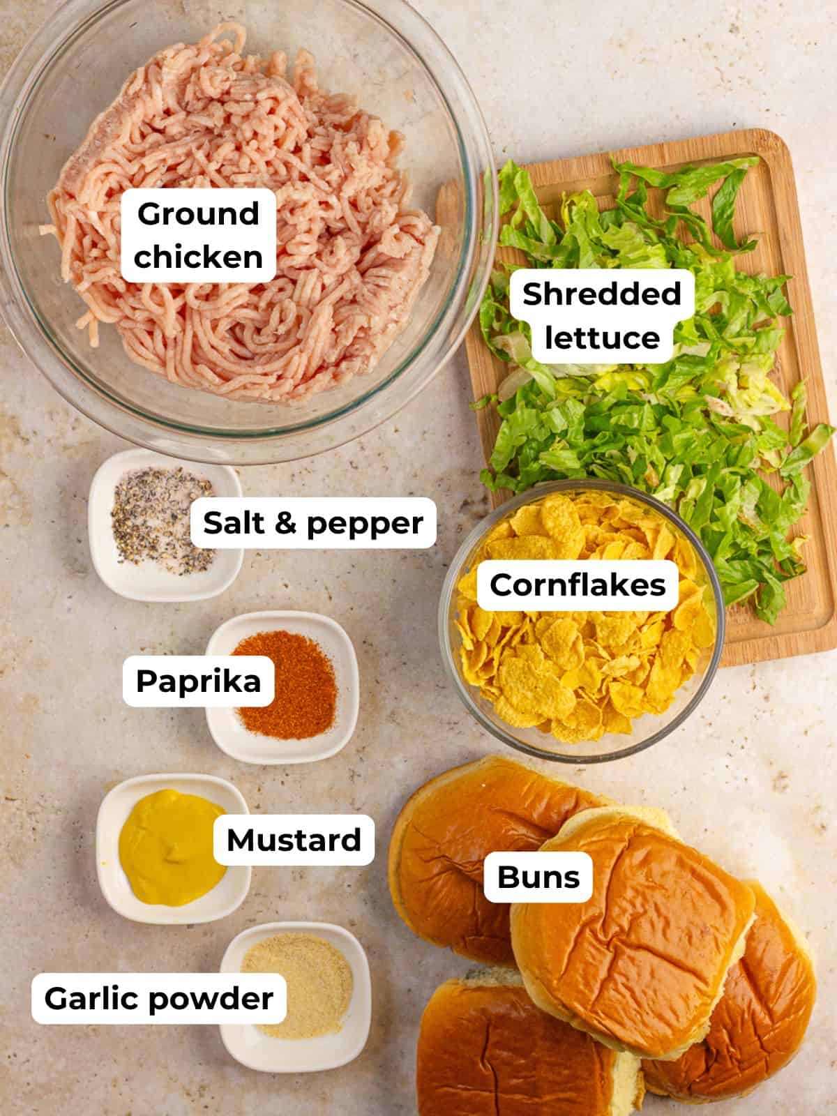 Ingredients for homemade McChicken sandwiches including ground chicken, cornflakes, buns, mustard, lettuce, and spices.