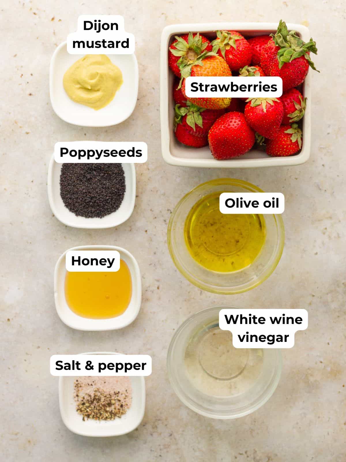 The ingredients for strawberry poppyseed dressing are labeled and arranged on a light countertop.