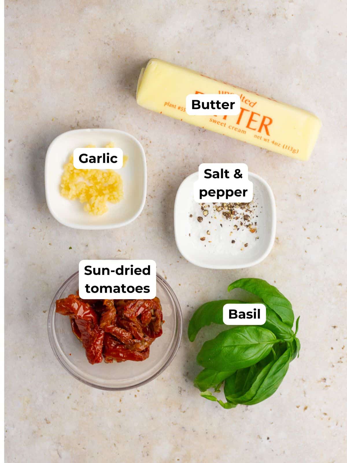 Butter, garlic, salt, pepper, sun-dried tomatoes, and fresh basil are labeled on a neutral background.