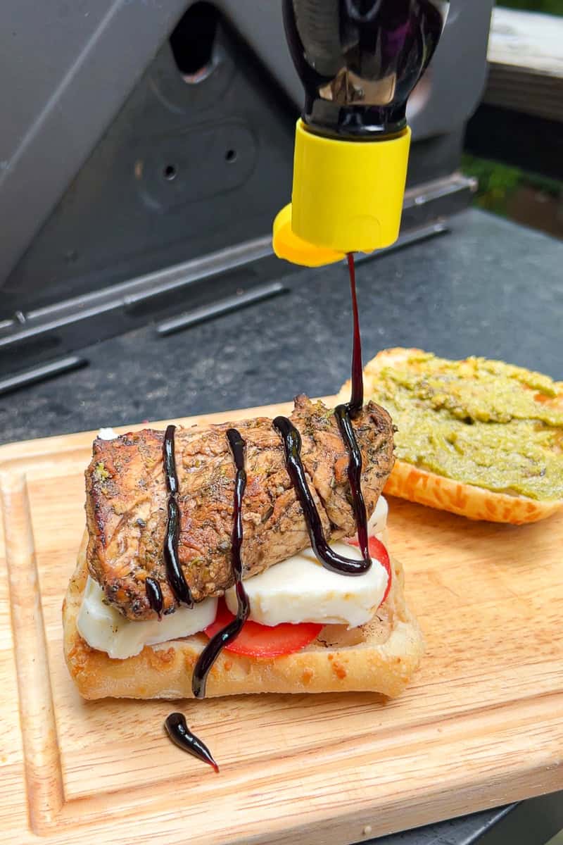Balsamic glaze is drizzled over grilled chicken, mozzarella, and tomato on toasted ciabatta bread.